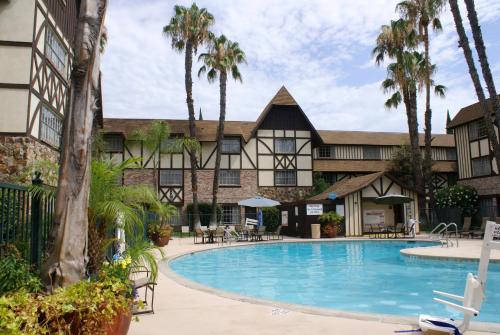 a resort with a swimming pool in front of a building at Anaheim Majestic Garden Hotel in Anaheim