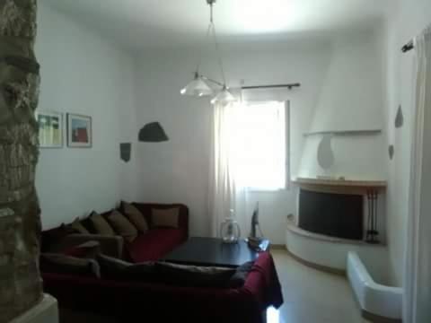 salon z kanapą i stołem w obiekcie elaiolithos w mieście Kóstos