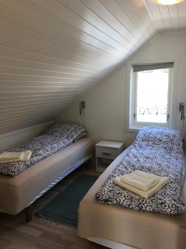 2 Betten in einem kleinen Zimmer mit Fenster in der Unterkunft Molobua, fantastic place by the sea in Leknes