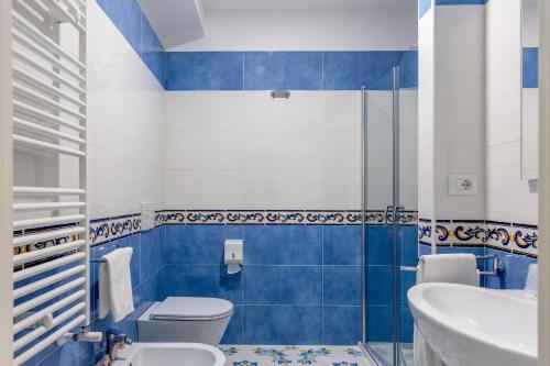 a blue and white bathroom with a toilet and a sink at Hotel Giosue' a mare Sorrento in Meta