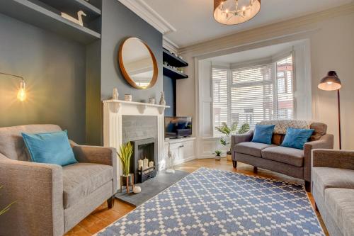 a living room with two chairs and a fireplace at Stones Throw in Whitby