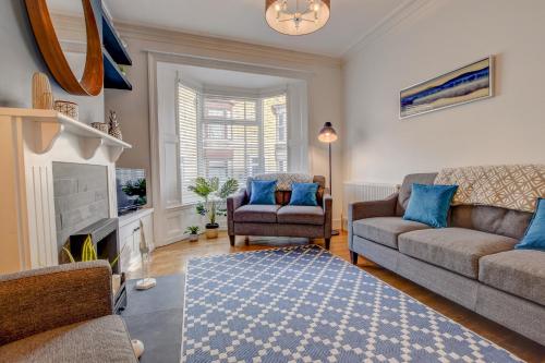 a living room with a couch and chairs and a fireplace at Stones Throw in Whitby