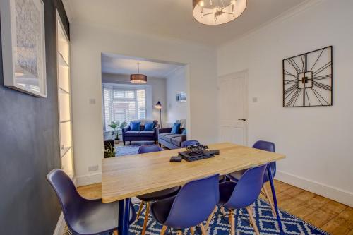 a dining room with a wooden table and blue chairs at Stones Throw in Whitby