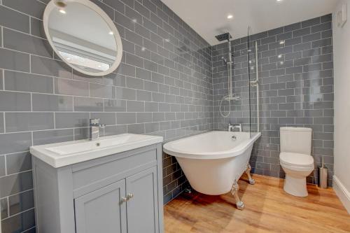 a bathroom with a tub and a sink and a toilet at Stones Throw in Whitby