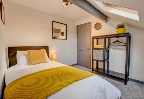 a bedroom with a bed with a yellow blanket at Stones Throw in Whitby