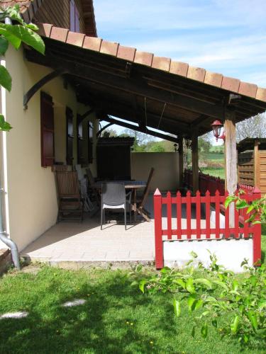 a patio with a red fence next to a house at La Bergerie du festel in Saint-Riquier
