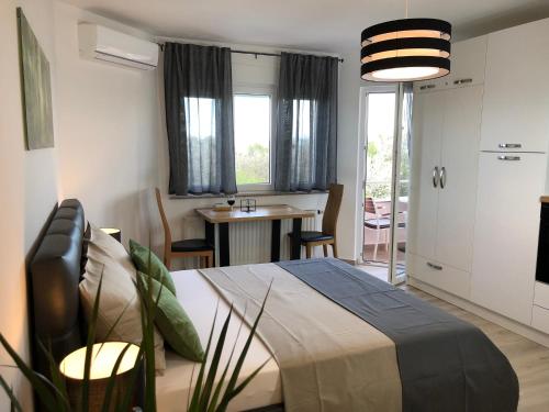 a bedroom with a bed and a table with chairs at Apartmani Učka in Opatija