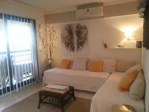 a living room with a white couch and a window at Acapulco Frejus Plage in Fréjus