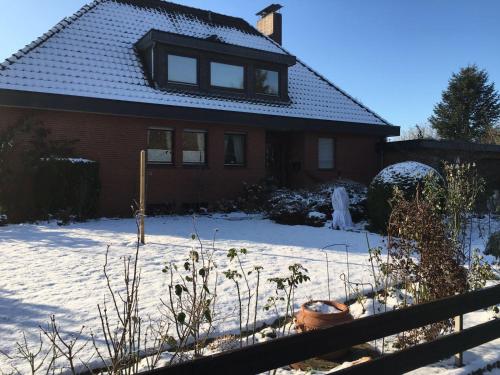 a house with snow on the ground in front of it at Ferienwohnung Christ in Wietzendorf