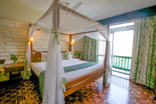 1 dormitorio con cama con dosel y balcón en Taita Hills Safari Resort & Spa, en Tsavo