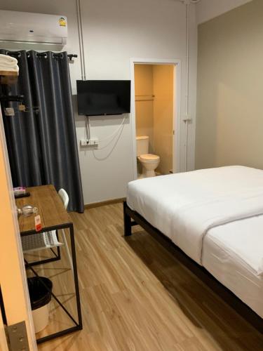 a bedroom with a bed and a television in a room at 9TY hotel (ninety hotel) in Bangkok