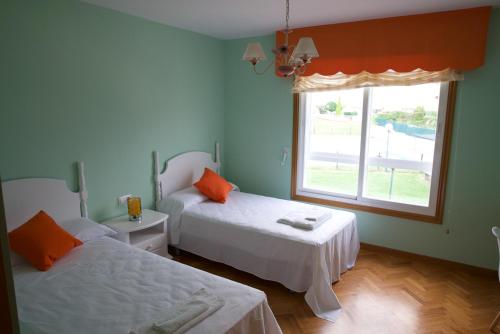 1 dormitorio con 2 camas y ventana en CHALET CON PISCINA EN MIÑO-Perbes, en Miño