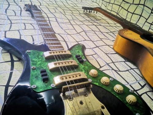 a green guitar sitting on top of a table at Hostel Sadu Kutaisi in Kutaisi