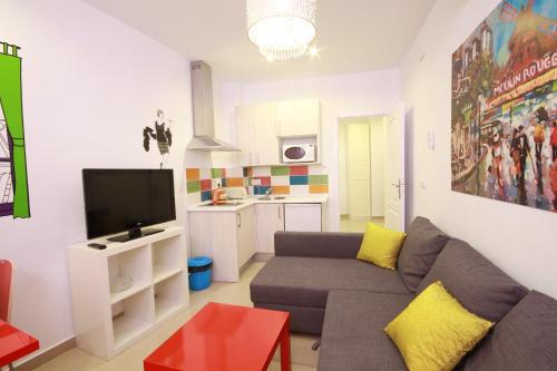 a living room with a couch and a tv at Apartamentos El Templo Suites in Merida