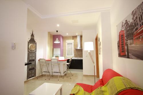 a living room with a table and a clock tower at Apartamentos El Templo Suites in Merida
