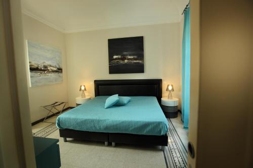 una camera da letto con un letto con lenzuola blu e due lampade di Abatellis Luxury a Palermo