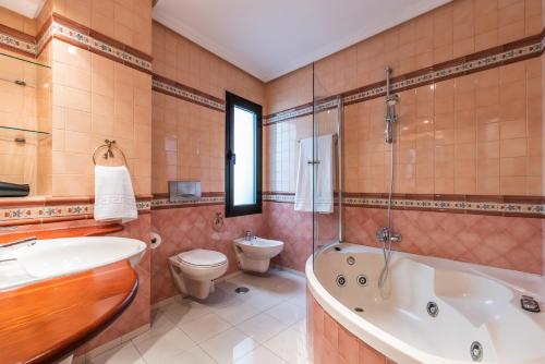 ein Badezimmer mit einer Badewanne, einem WC und einem Waschbecken in der Unterkunft CASA MIRAFLORES in Málaga