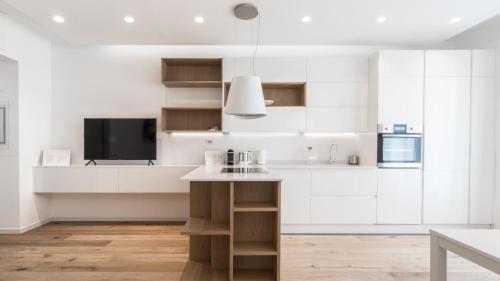 a kitchen with white cabinets and a flat screen tv at Italianway - De Cristoforis 12 Flat in Milan