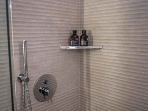 two bottles of alcohol sit on a shelf in a shower at My Luxury Suites - Standard in Savona