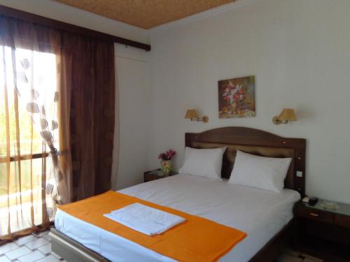 a bedroom with a bed and a window at Angela Hotel in Agia Marina Aegina