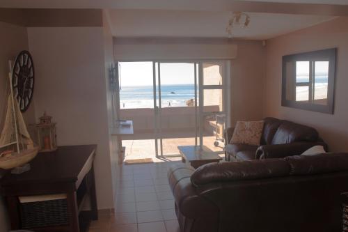 a living room with a couch and a view of the beach at At home on the beach... in Jeffreys Bay