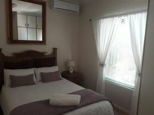une chambre avec un lit avec un miroir et une fenêtre dans l'établissement Overmeer, à Worcester