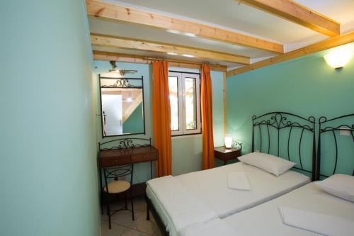 a bedroom with two beds and a mirror at FOUFAS HOUSES in Paralio Astros