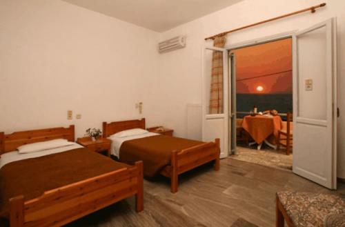 a bedroom with two beds and a table with a dining room at Nautilus Apartments in Sisi