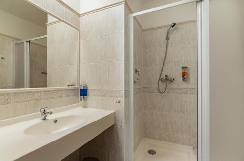 y baño con lavabo y ducha. en Penzion Fan en Karlovy Vary