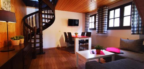 a living room with a spiral staircase and a table at Gästehaus Behabühl in Feldberg