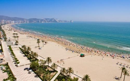 a group of people on a beach with the ocean at Apartamento ÉLITE en Cullera playa San Antonio in Cullera