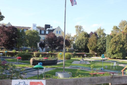 a park with a playground with trees and buildings at Sonnengarten 10 - Ruhepol in Kellenhusen