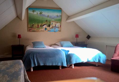 two beds in a room with a painting on the wall at Anjou Golf and Country Club in Champigné