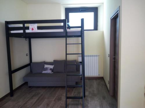 1 dormitorio con litera y sofá en MONOLOCALE centro storico Pratovecchio completamente ristrutturato, en Pratovecchio