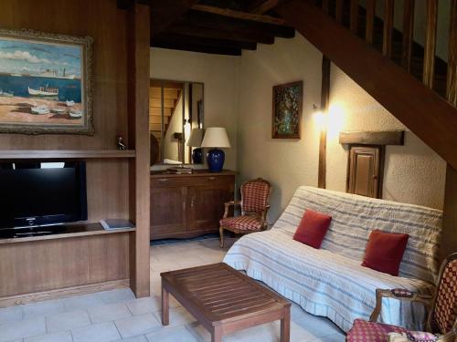 a living room with a couch and a tv at Anjou Golf and Country Club in Champigné