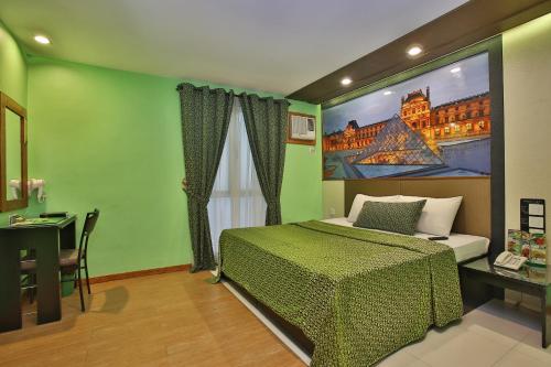 a bedroom with a bed with a painting on the wall at Eurotel Vivaldi Araneta in Manila