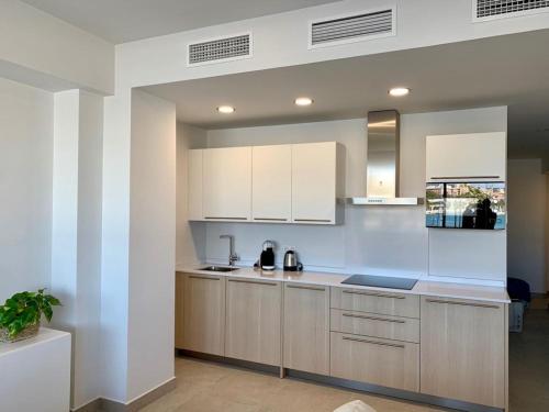 a kitchen with white cabinets and a counter top at Diamond Apartments Puerto De Malaga in Málaga