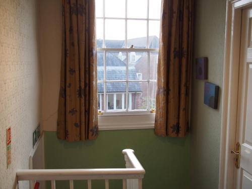 a window in a room with a crib and a window at The Coach House in Canterbury