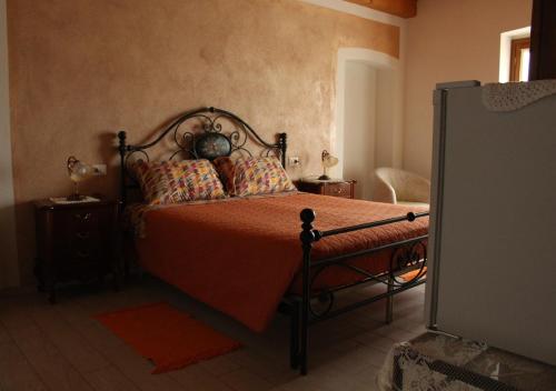 a bedroom with a bed with orange sheets and pillows at Ca d'Pinin in Albugnano 