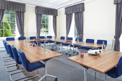 a conference room with wooden tables and blue chairs at Eastwood Hall in Eastwood