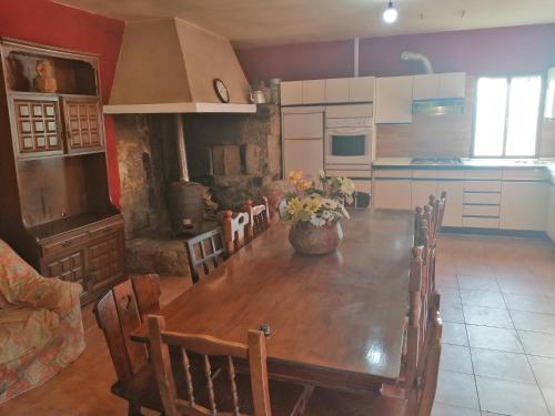 a kitchen with a wooden table with a vase of flowers on it at Casa Marina in Caldas de Reis