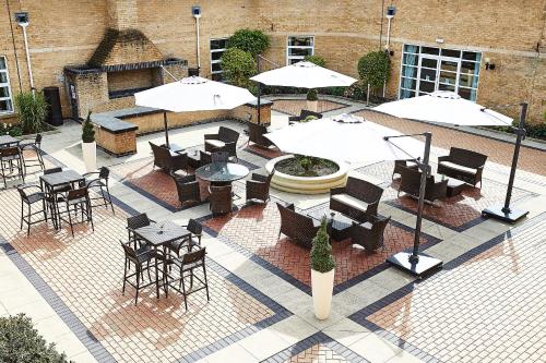 an outdoor patio with tables and chairs and umbrellas at Eastwood Hall in Eastwood