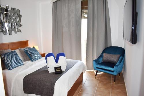 a bedroom with a bed and a blue chair at VILLA MOLEIRO- LA TEJITA in La Tejita