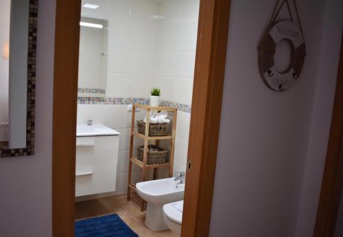 a bathroom with a white toilet and a sink at VILLA MOLEIRO- LA TEJITA in La Tejita