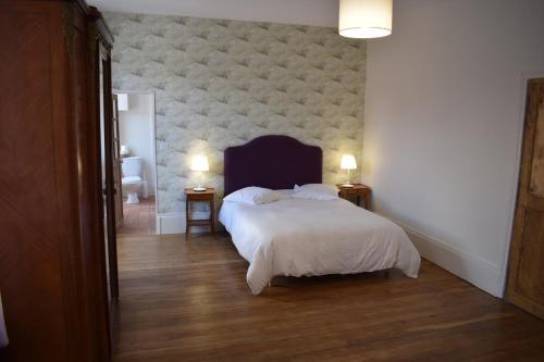 - une chambre avec un lit blanc et 2 tables avec des lampes dans l'établissement L'Aventure, à Châteauneuf-sur-Loire