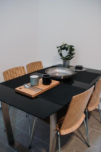 a black table with chairs and a plate on it at JAM Luxury Apartment in Győr