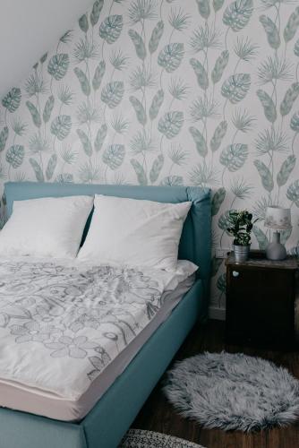 a bed with a blue headboard in a bedroom at JAM Luxury Apartment in Győr
