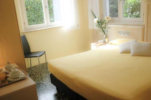 a bedroom with a bed and a table and a chair at Hotel Santa Lucia in Venice