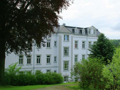 a white house on a hill with trees at Excellent Villa in Borstendorf with Garden in Grünhainichen