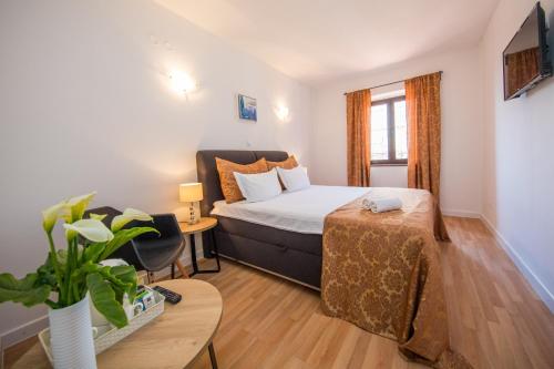 a small bedroom with a bed and a table at Villa Dard in Dubrovnik